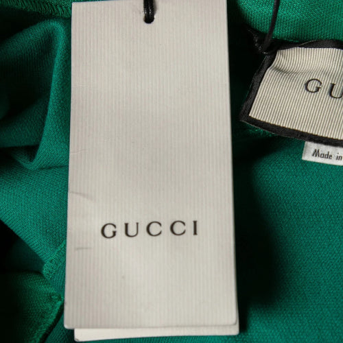Gucci packaging and tags on a green fabric background