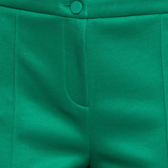 Close-up of green pants with a button detail