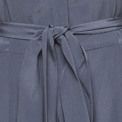 Close-up of a slate blue-gray belted garment, showing the fabric texture and tie detail.