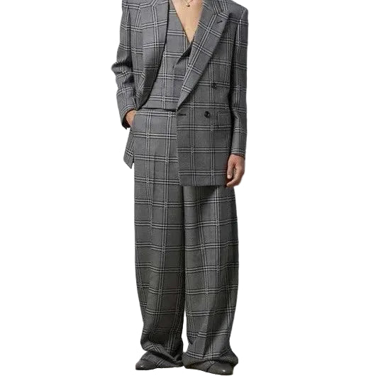 Person wearing a gray plaid suit against a plain background