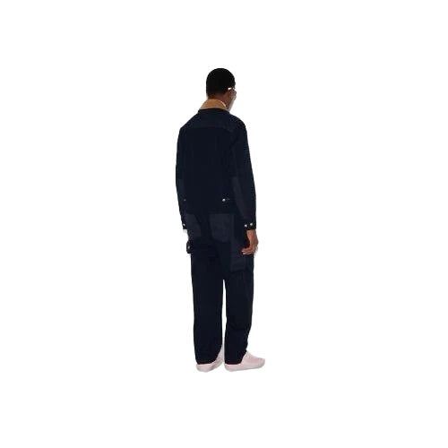Person wearing a black outfit standing on a white background