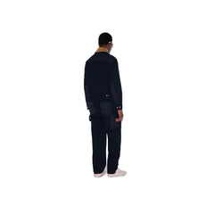 Person wearing a black outfit standing on a white background