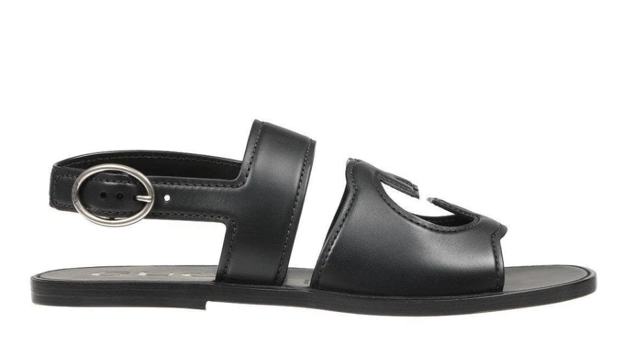Black sandal with a metallic buckle on a white background