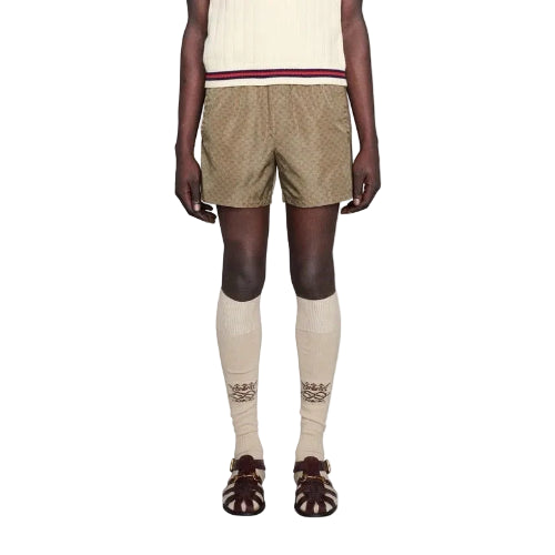 Person wearing beige shorts and knee-high socks on a white background