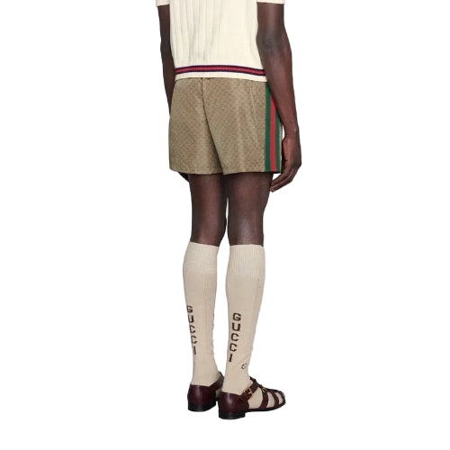 Person wearing a beige skirt, white top, and knee-high socks with a visible brand logo.