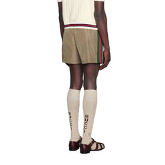 Person wearing a beige skirt, white top, and knee-high socks with a visible brand logo.