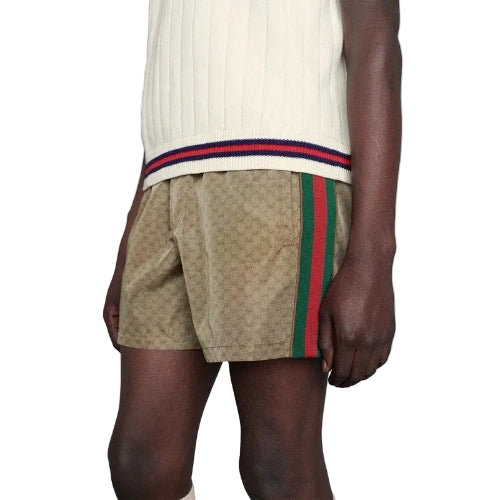 Person wearing a patterned shorts with a brand logo on a plain background