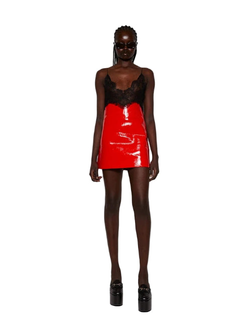 Person wearing a red vinyl skirt on a white background
