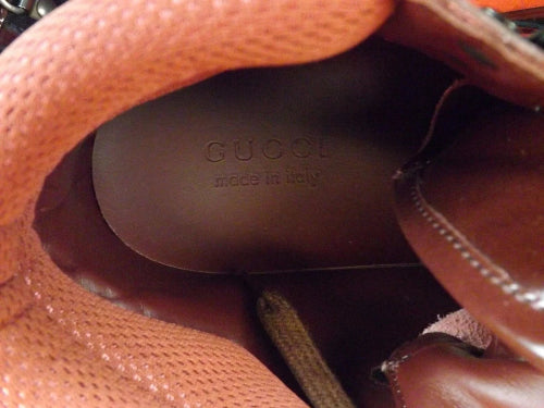 Close-up of a brown leather shoe with a visible brand logo.