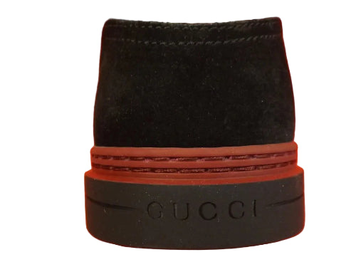 Black Gucci bottle stopper on an orange background