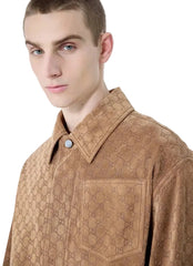 Man wearing a brown textured shirt against a neutral background