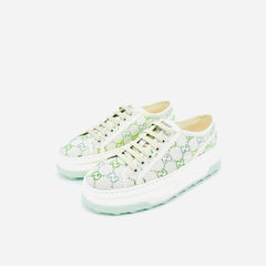 A pair of Gucci low-top sneakers featuring a white canvas upper with a green GG monogram pattern, white laces, and a chunky white platform sole with a light mint green tint.