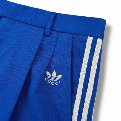 Blue pants with white stripes and Gucci logo on a white background