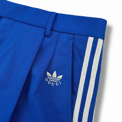Blue pants with white stripes and Gucci logo on a white background