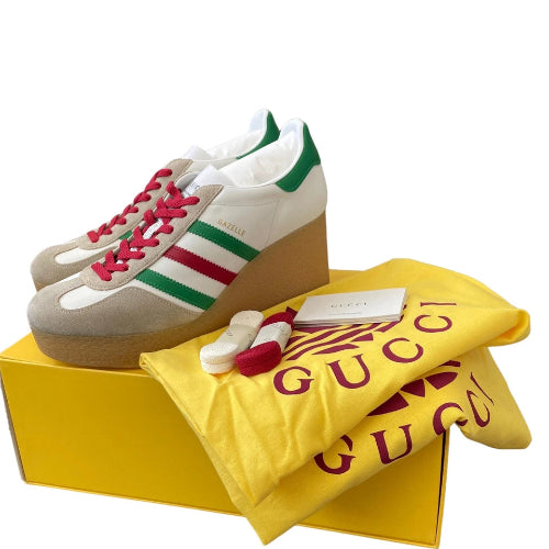 Gucci Sabaia platform sneakers in beige suede and white leather with green and red stripes, pink laces, shown with a yellow Gucci dust bag and yellow box on a white background.