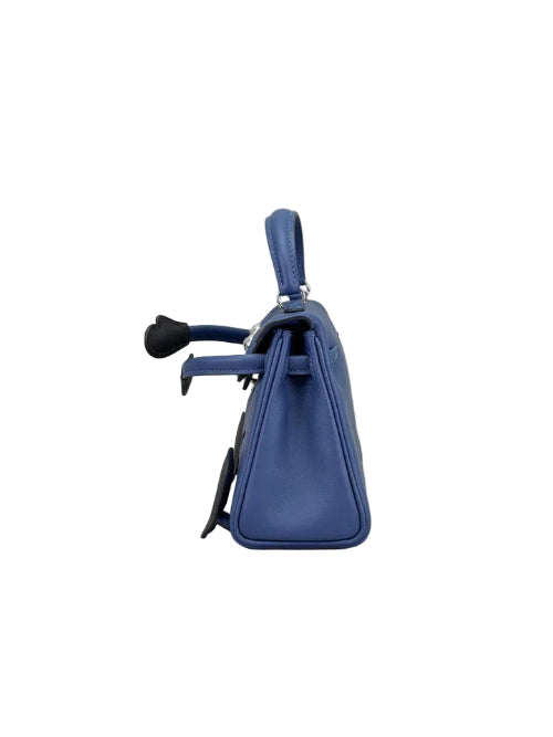 A blue leather handbag shown from a side profile view against a neutral light gray background.