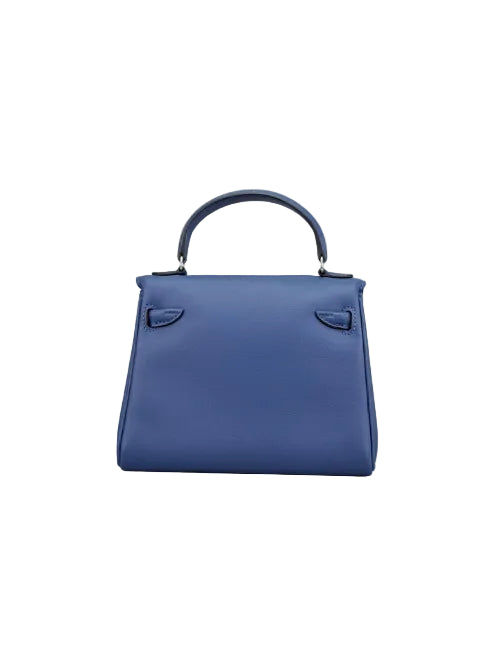 A medium blue leather top-handle handbag with silver-tone hardware, photographed against a neutral light gray studio background.