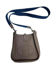 Brown handbag with a blue strap on a white background