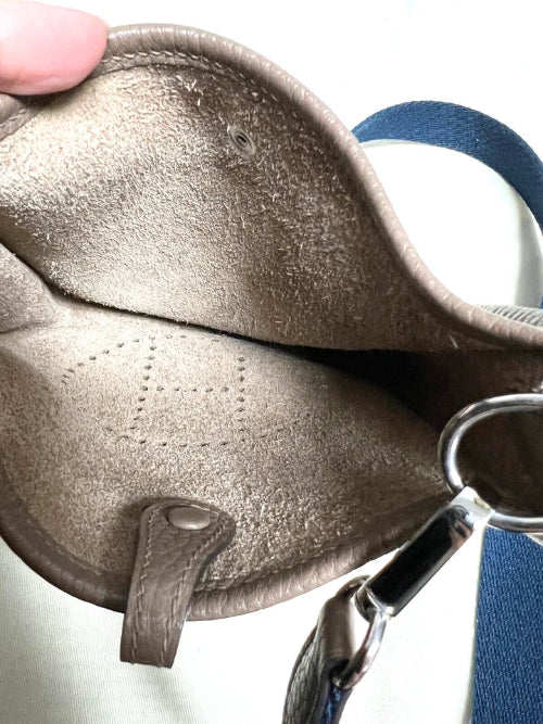Close-up of a metallic gold bra with scissors in the foreground on a white background
