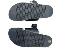 Black sandals with textured soles on a wooden floor