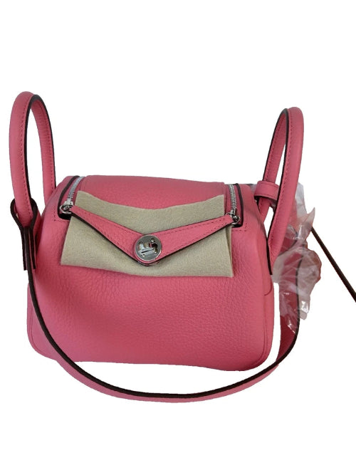 Pink handbag with beige flap on a white background