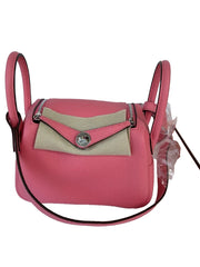 Pink handbag with beige flap on a white background