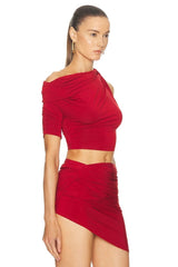 Woman wearing a red off-shoulder top and skirt set on a white background