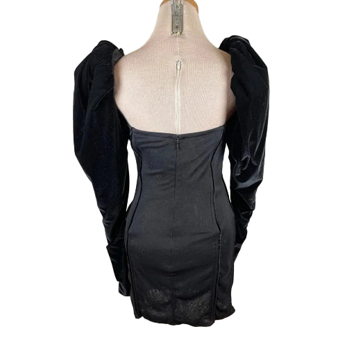 Black dress on a mannequin with a plain background