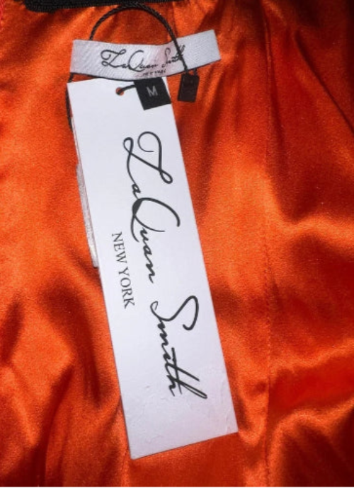 Laquan Smith label on an orange fabric background