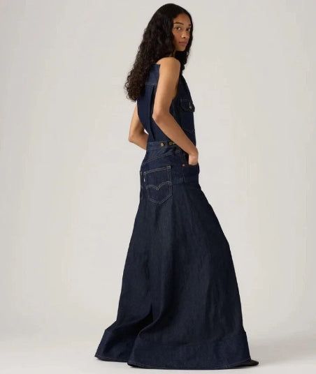 Woman wearing a long denim dress against a white background