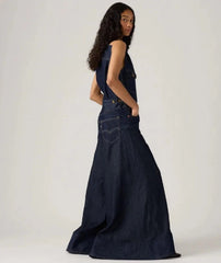 Woman wearing a long denim dress against a white background