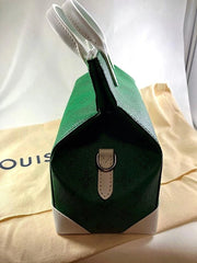 Green handbag with a white strap on a beige surface