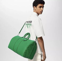 Person carrying a green duffel bag on a plain background