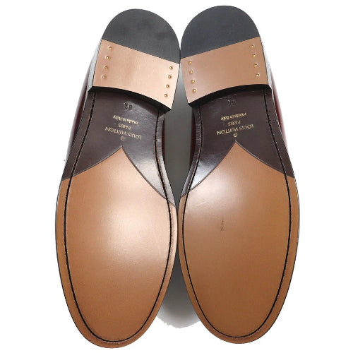 Pair of men's dress shoes with brown soles on a white background
