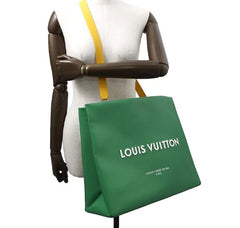 Green Louis Vuitton bag on a mannequin with a white background