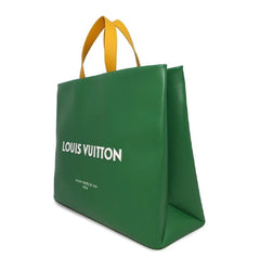 Green Louis Vuitton bag with yellow handles on a white background