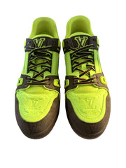 Pair of neon green and brown sneakers on a box with a neutral background
