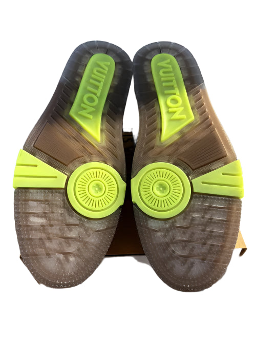 Brown sandals with green soles and 'Louis Vuitton' branding on a white background