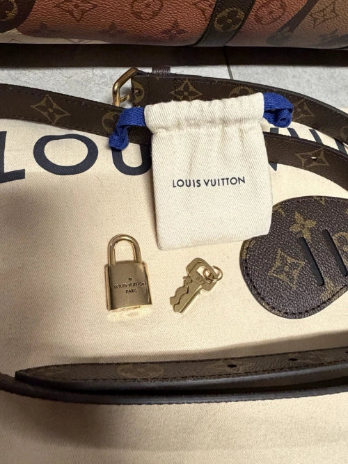 Louis Vuitton lock and key set with packaging on a branded surface