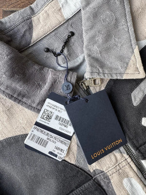 Close-up of a gray coat with a visible brand tag on a white background