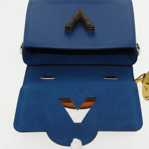 Blue handbag with a distinctive V-shaped design on a white background