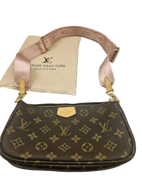 Louis Vuitton handbag with monogram pattern and pink strap on a white surface.