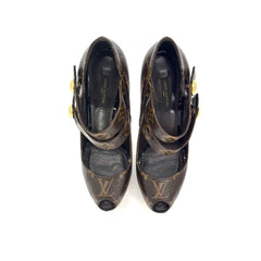 A pair of Louis Vuitton monogram pointed-toe pumps with open toes, ankle straps, and gold-tone buckle details, shown from a top-down view on a white background.