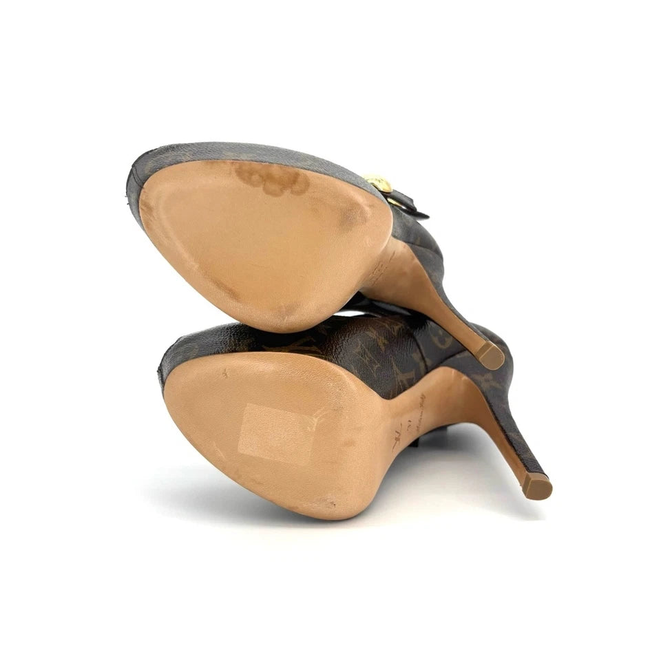 Louis Vuitton monogram pointed-toe mule heels shown from the bottom, displaying the tan rubber outsole and high stiletto heel on a white background.