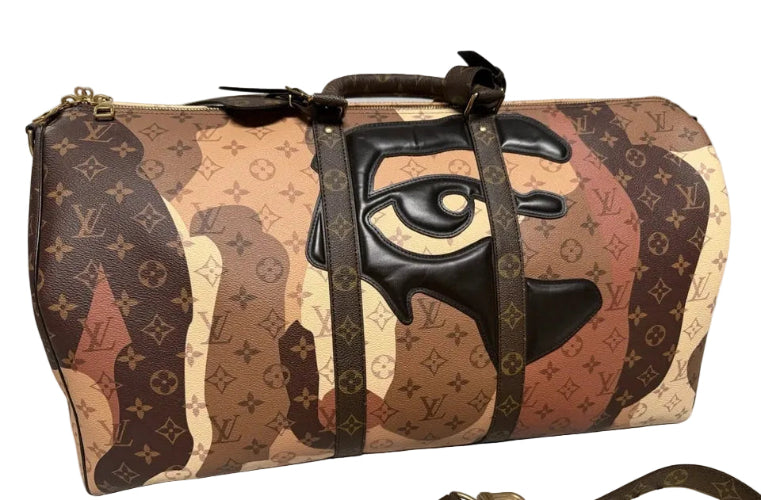 Designer handbag with monogram pattern and prominent logo on a light gray background