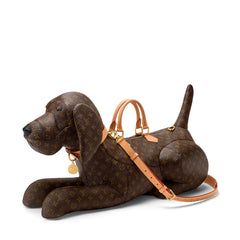 A brown plush dog-shaped bag with a tan strap and handle, photographed against a plain white background.