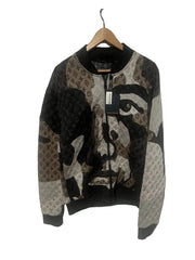 Knitted sweater with face design on a hanger against a white background