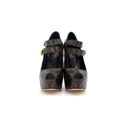 A pair of black patent leather Mary Jane shoes with a brown and black damask patterned strap, shown from a top-down view on a white background.