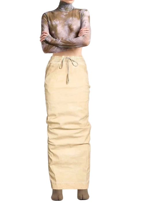 A model wearing a beige drawstring skirt and a brown and beige patterned long-sleeve mock neck top, standing against a light gray studio background.