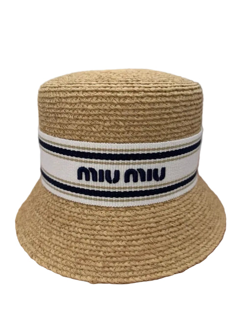 Beige straw hat with Miu Miu band on a brown surface